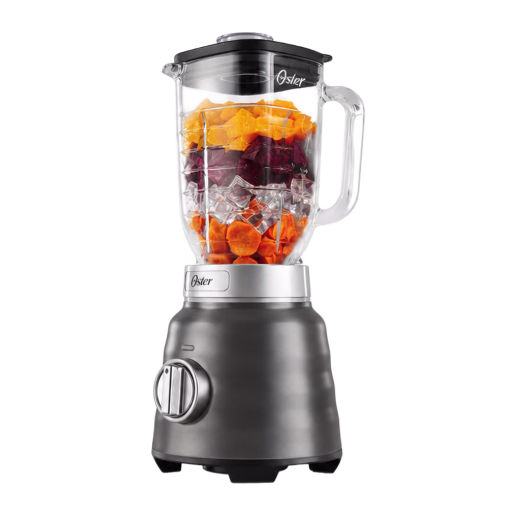 Licuadora Oster BLSTPBRGR con vaso de vidrio, frutas y base negra, vista lateral