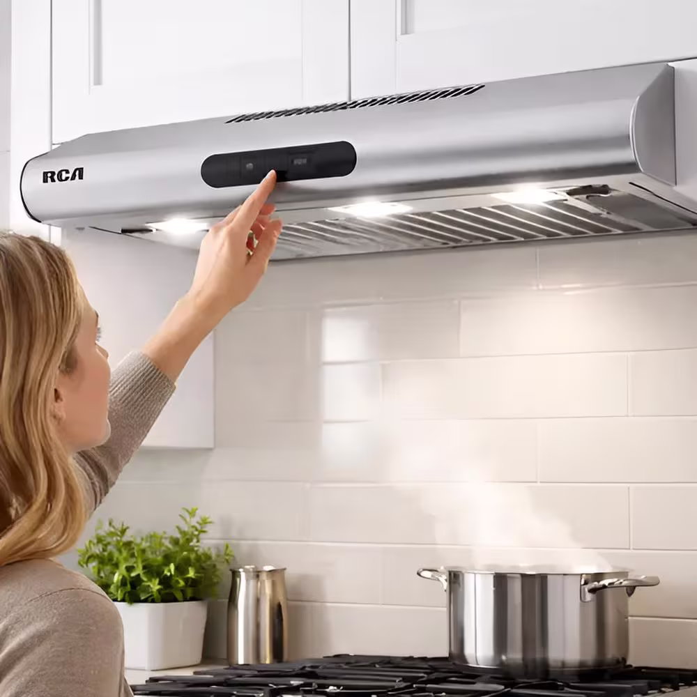 Campana extractora RCA 60S-I encendida extrayendo vapor en cocina vista tres cuartos. Solo en granhogar online