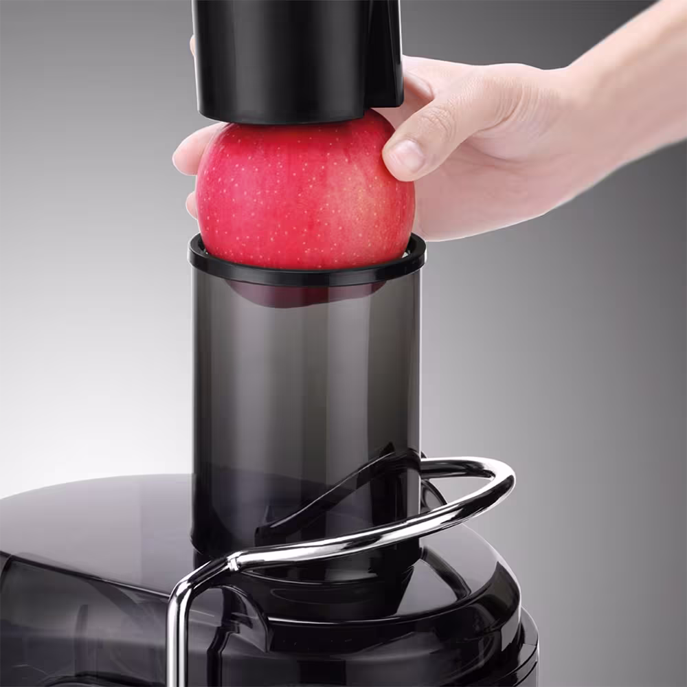 Extractor de jugo Prima AJ10B ingresando fruta en tubo de entrada primer plano. Encuéntrala en granhogar